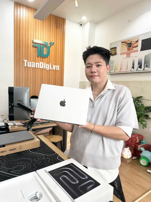 Khách hàng với MacBook Pro màu bạc tại cửa hàng TuanDigi